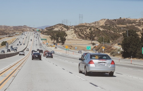 Traffic fills a highway on a sunny day.