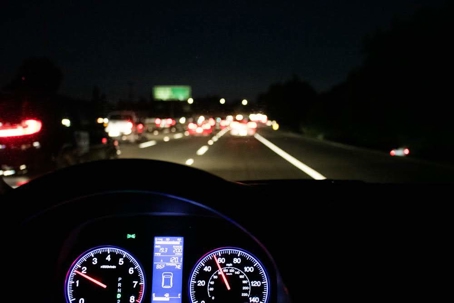 From the driver's perspective, a car navigates a crowded highway at night