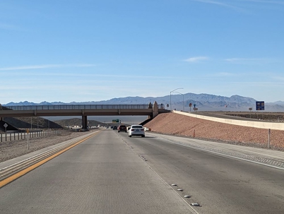 Highway view with a bridge overhead on a clear day