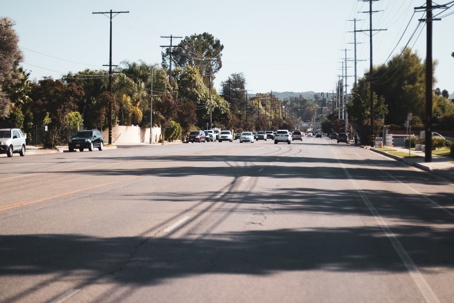 This is a photo of a road with cars parked