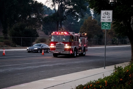 A fire truck drives down a road