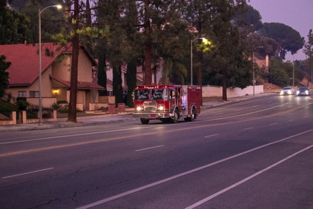 A firetruck speeds along a residential street