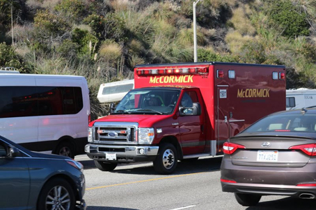 A red McCormick ambulance is stuck in traffic