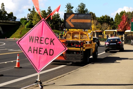 a road with a wreck ahead sign