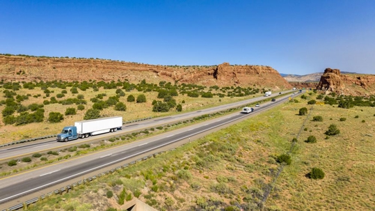a truck driving on a highway through a desert